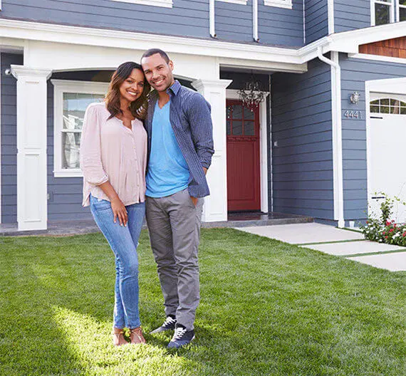 Happy couple in front of new house